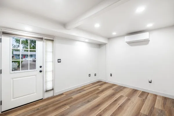 a view of a room with wooden floor and white walls