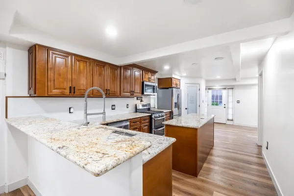 an empty room with wooden floor cabinet and windows