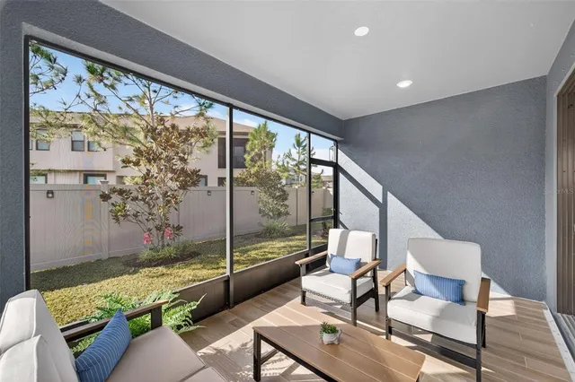 a view of a swimming pool with a lawn chairs under palm trees