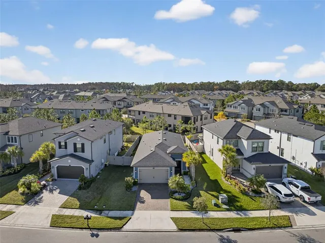 an aerial view of a residential houses with outdoor space and lake view