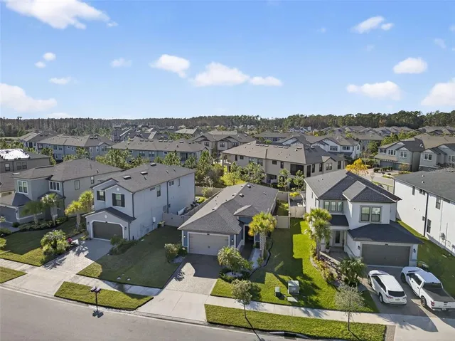 an aerial view of a house with a yard and large trees