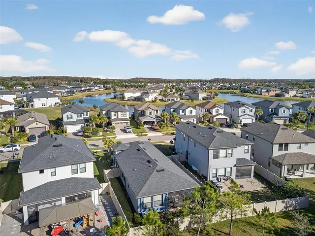 an aerial view of residential house with outdoor space and trees all around