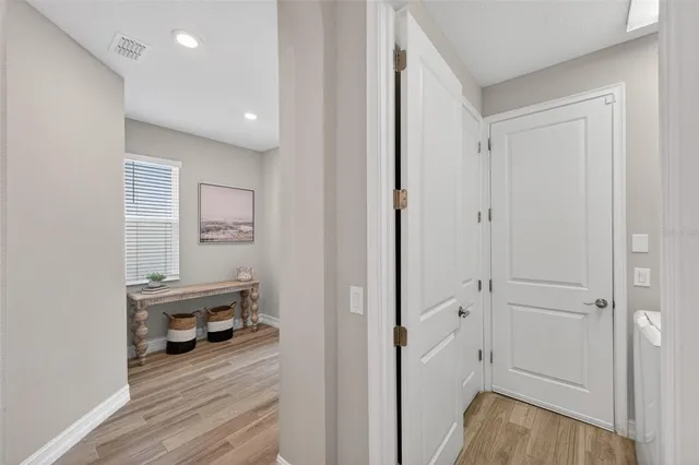 a view of a hallway with wooden floor and closet area