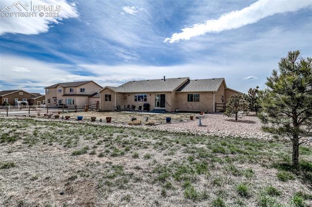 9737 Rockingham Drive Peyton, CO 80831 - Photo 26 of 28 ~The huge backyard has an area with natural growth, as well as an area that has manicured grass with sprinklers and a drip system for the pots~
