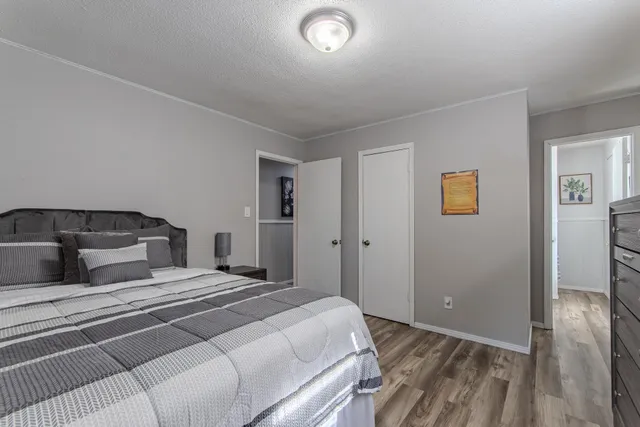 a bedroom with a bed and painting on the wall