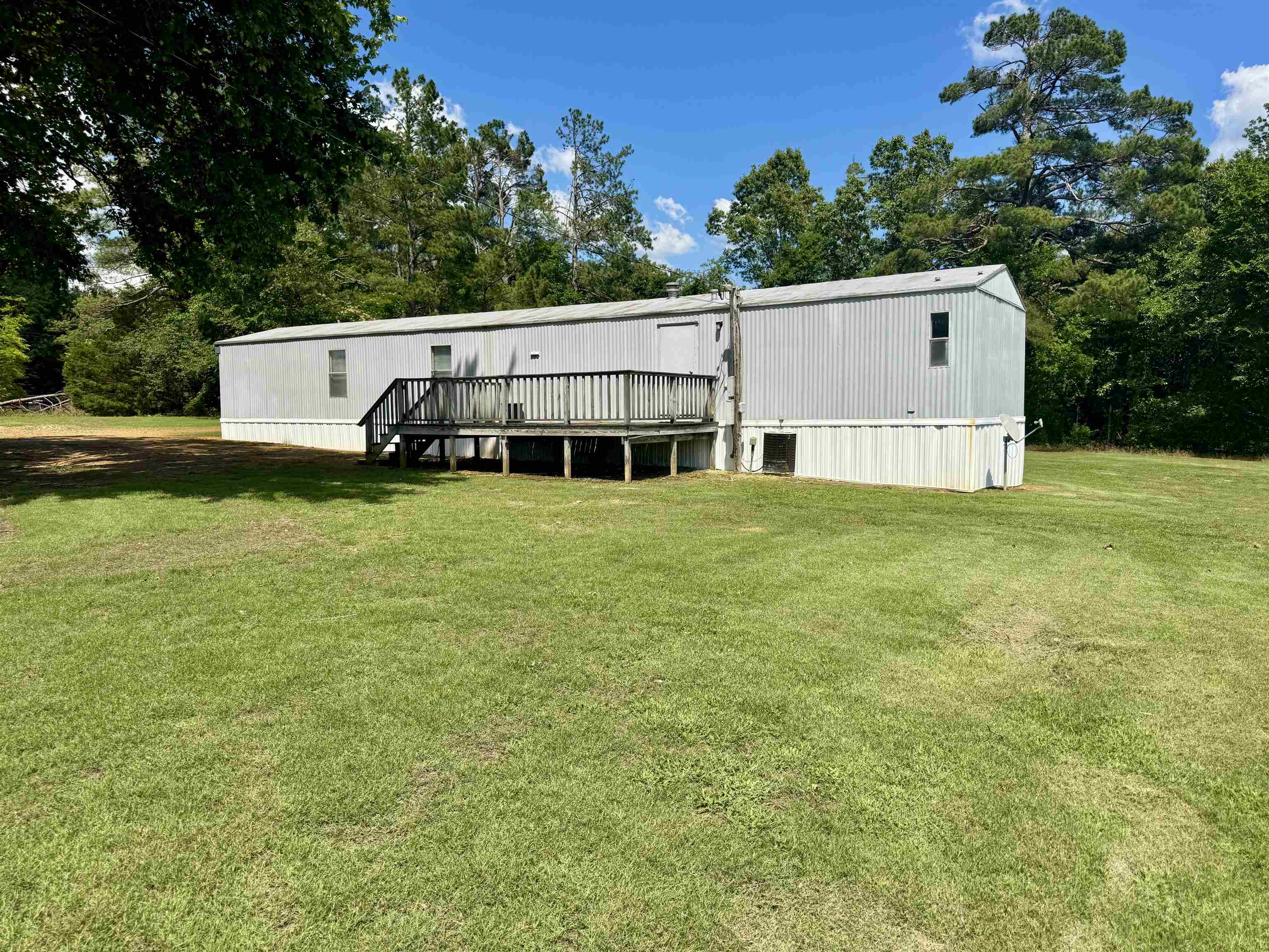 2511 Watkins Road Michie, TN 38357 - Photo 32 of 40 Spacious rear yard with a wooden deck and privacy railing, surrounded by mature trees