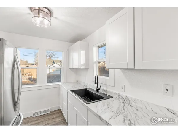 a kitchen with granite countertop a sink a stove and cabinets