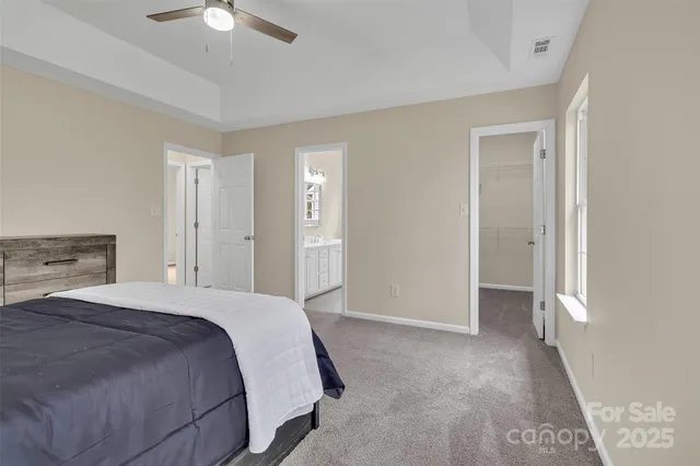 a spacious bedroom with a bed and a chandelier