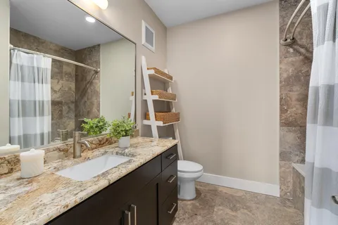 a bathroom with a granite countertop sink and a mirror