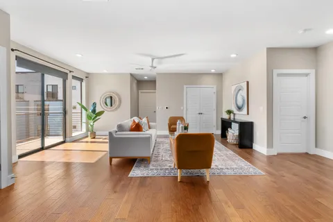 a living room with furniture and a wooden floor