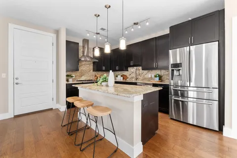 a kitchen with stainless steel appliances kitchen island a refrigerator and a stove top oven