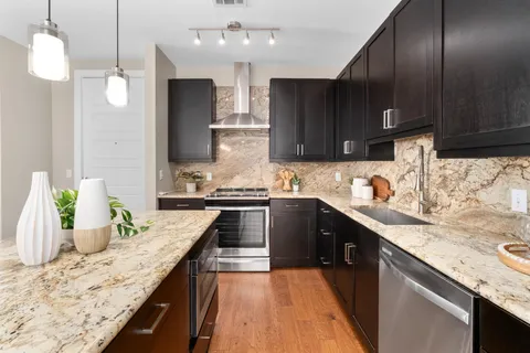 a kitchen with granite countertop wooden cabinets a sink and dishwasher