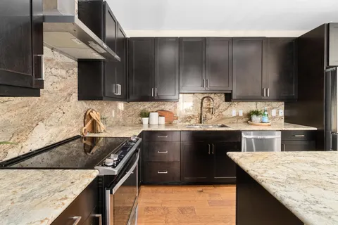 a kitchen with granite countertop wooden cabinets and a sink