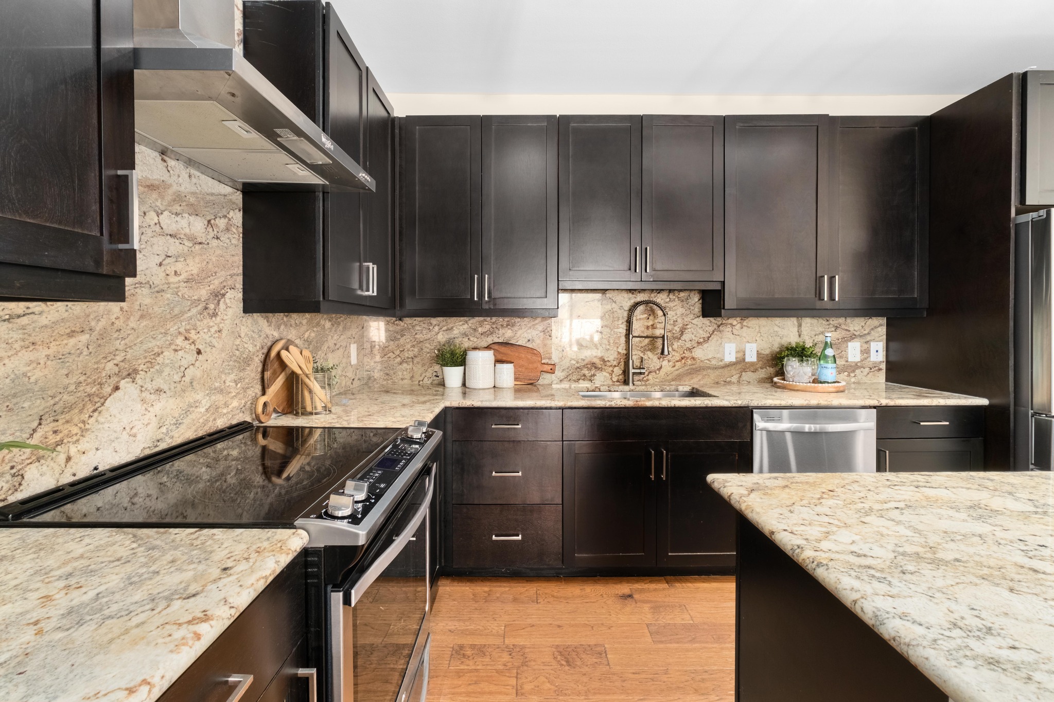 1615 East 7th Street, Unit 402 Austin, TX 78702 - Photo 8 of 23 a kitchen with granite countertop wooden cabinets and a sink