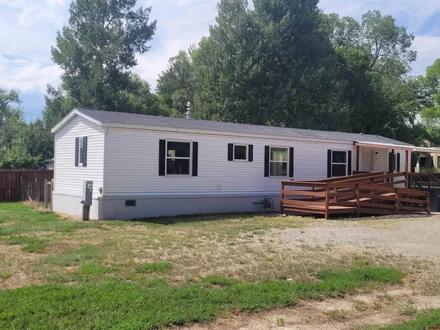 a view of a house with a yard and a wooden fence