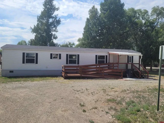a view of a house with backyard and trees