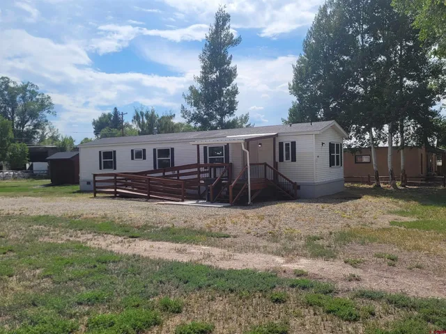 a view of a house with backyard and trees