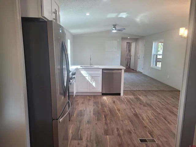 a kitchen with a refrigerator stove and wooden cabinets