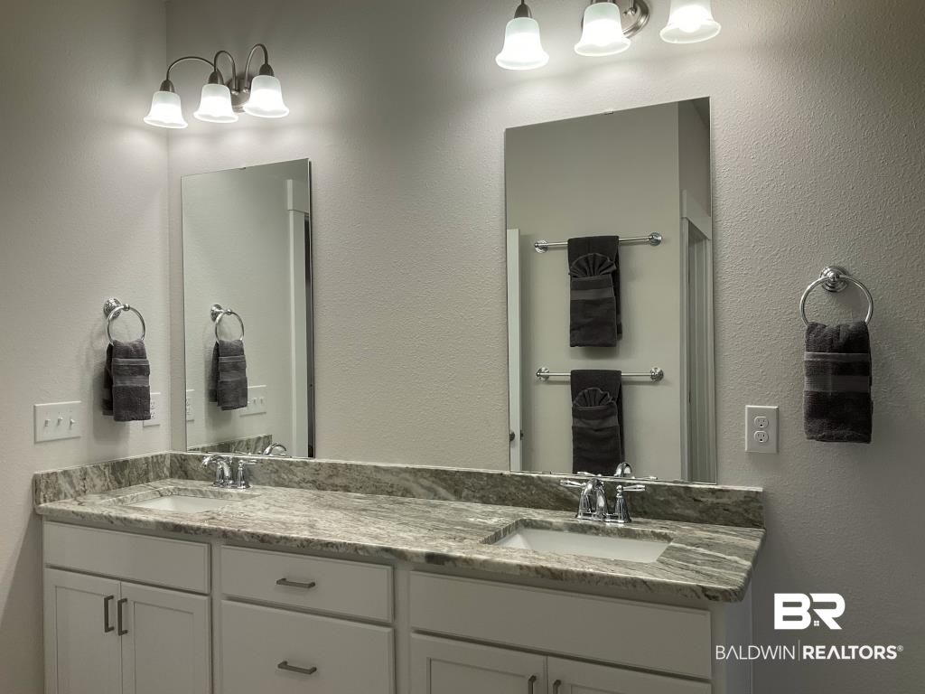 1093 Pheasant Circle Foley, AL 36535 - Photo 12 of 25 Bathroom featuring a textured wall, double vanity, and a chandelier