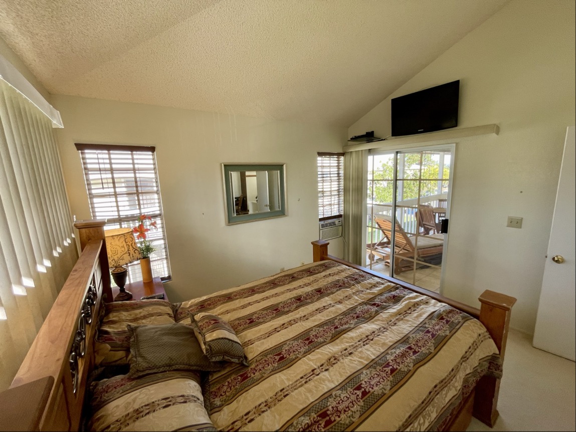 68-3883 Lua Kula Street, Unit 2005 Waikoloa, HI 96738 - Photo 19 of 28 a bedroom with a bed and a flat tv screen on the dresser