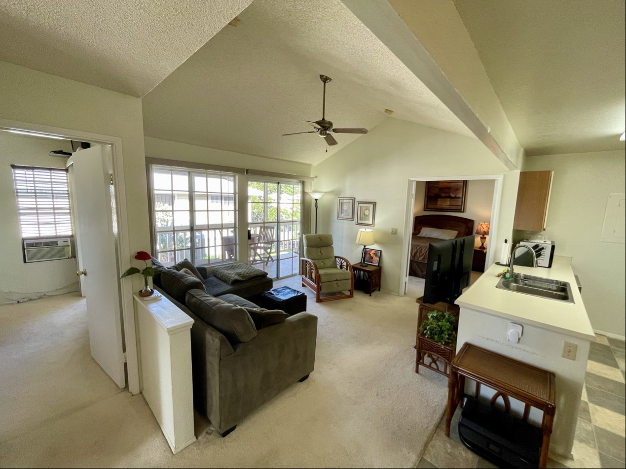 68-3883 Lua Kula Street, Unit 2005 Waikoloa, HI 96738 - Photo 4 of 28 a living room with furniture a fireplace a flat screen tv and windows