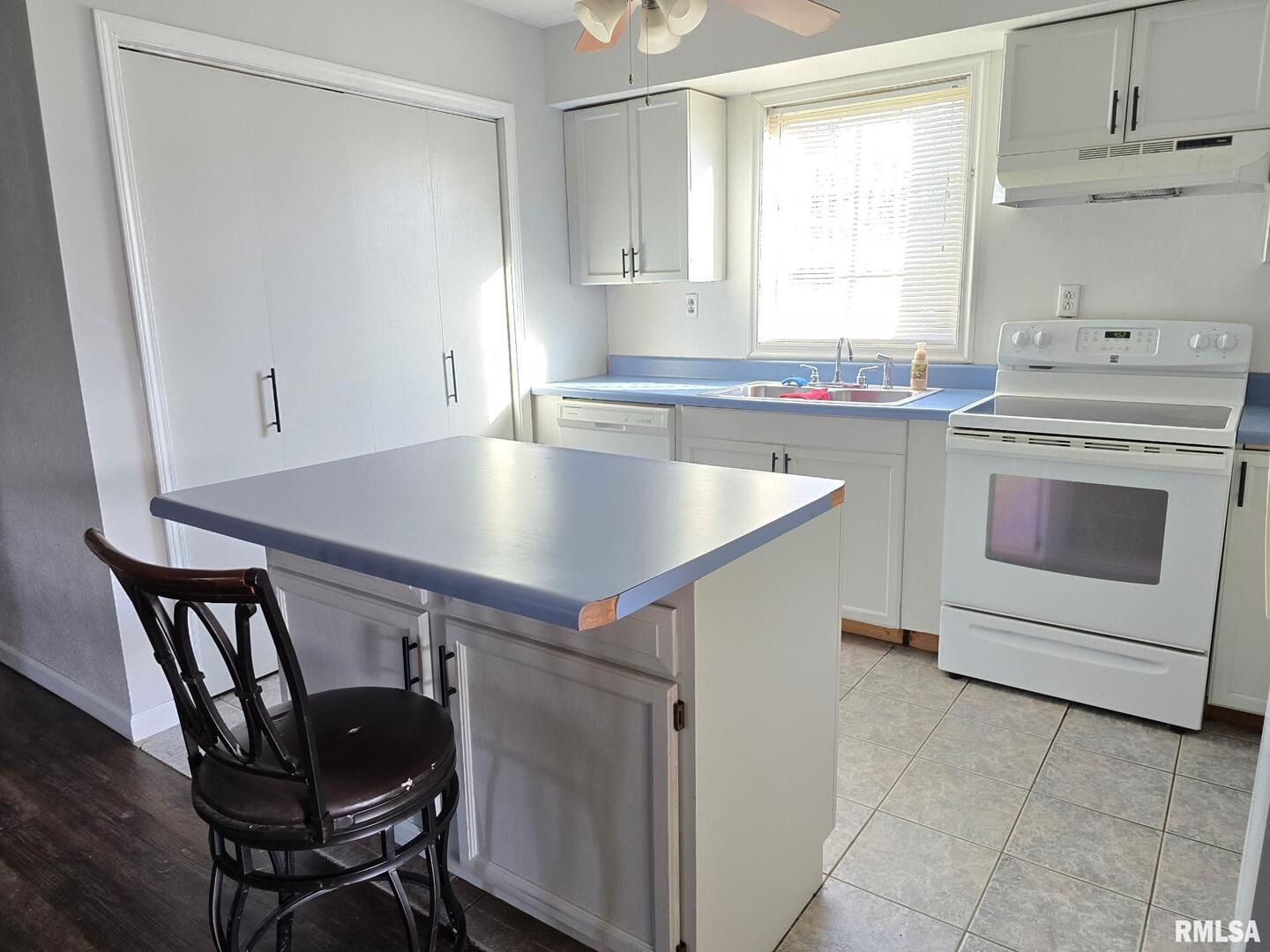 1100 Moore Street Eldorado, IL 62930 - Photo 6 of 20 a kitchen with stainless steel appliances granite countertop a sink a stove a table and a refrigerator