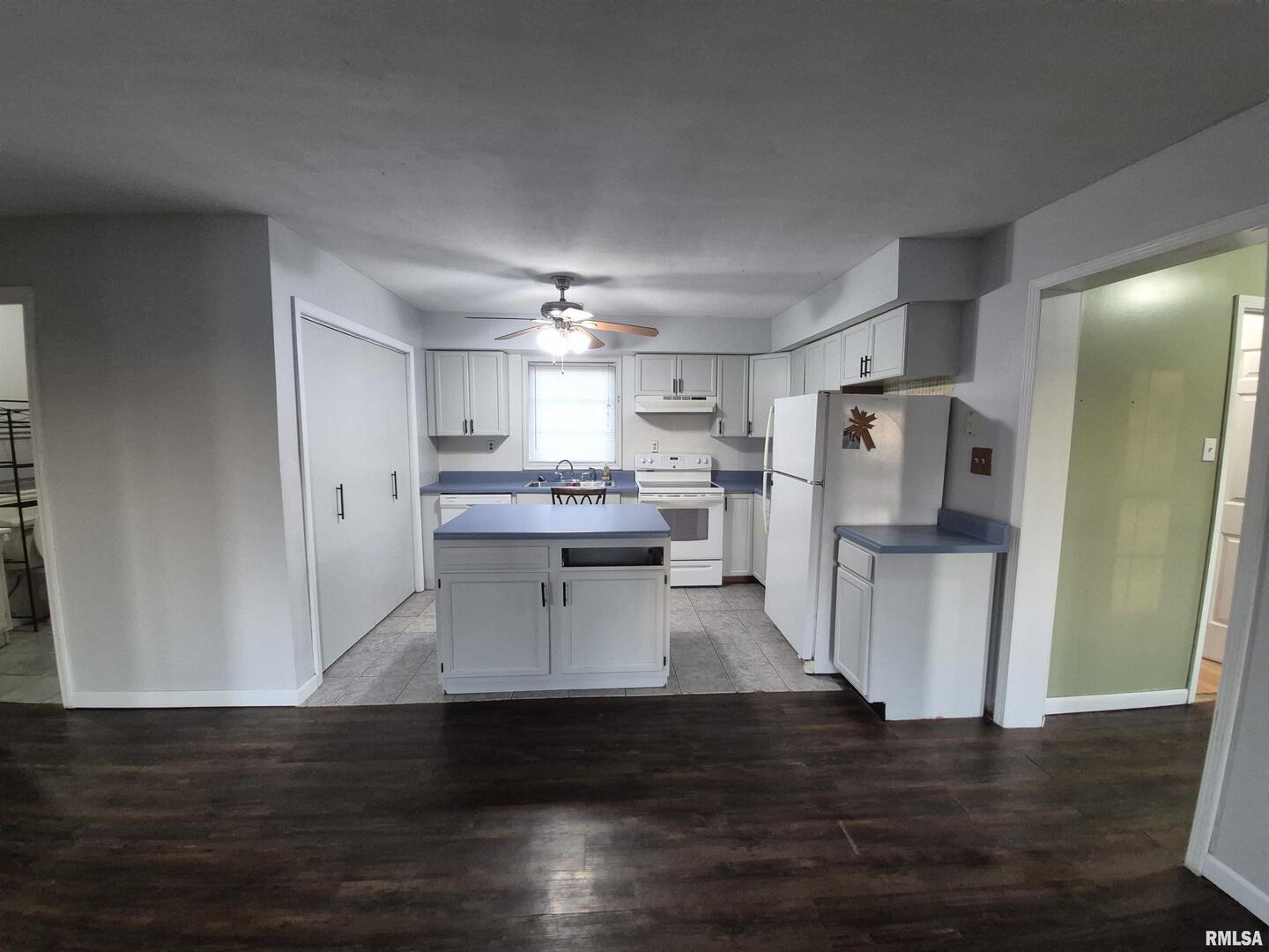 1100 Moore Street Eldorado, IL 62930 - Photo 8 of 20 a view of a kitchen with refrigerator and wooden floor