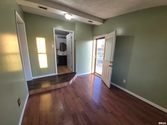 a view of a hallway with wooden floor and windows