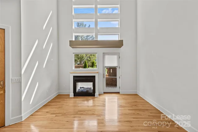 a view of an empty room with a window and fireplace
