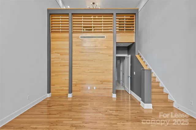 a view of a hallway with wooden floor and staircase