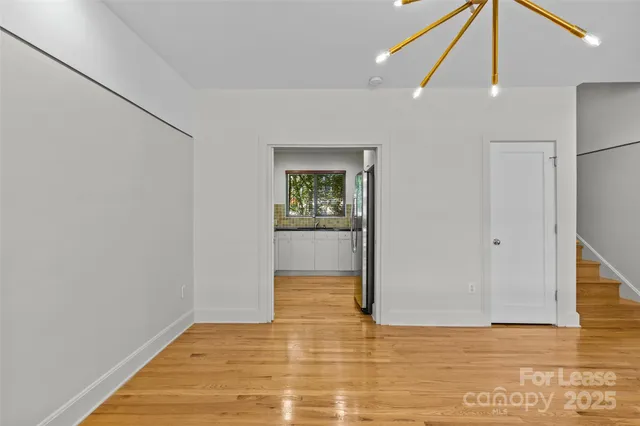 a view of a big room with wooden floor and windows