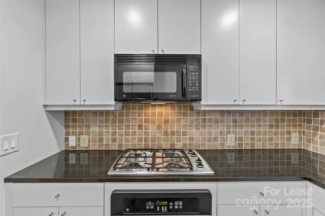 a kitchen with a stove a microwave and sink