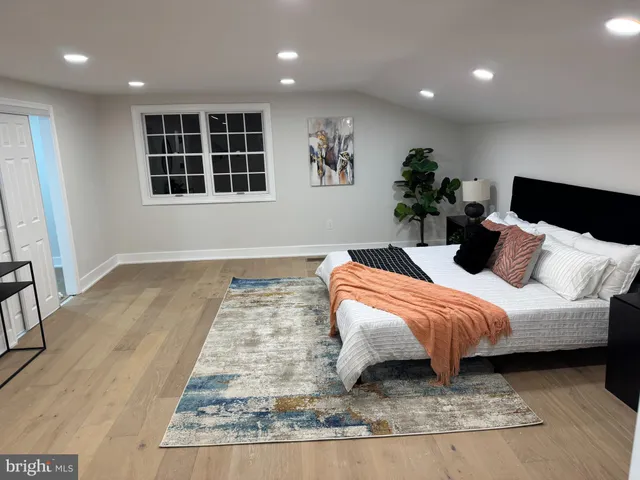 a bedroom with a large bed and a potted plant