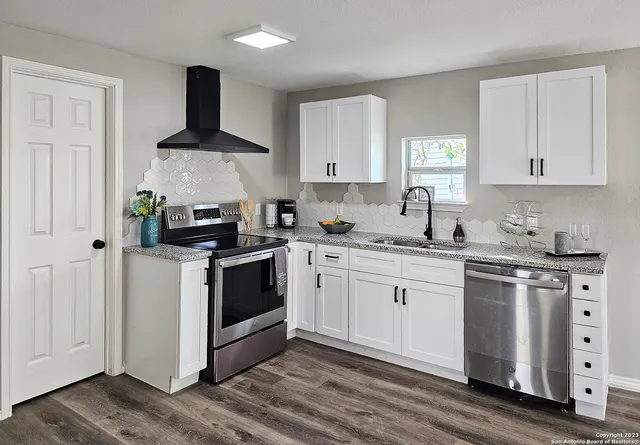 a kitchen with granite countertop white cabinets and white appliances