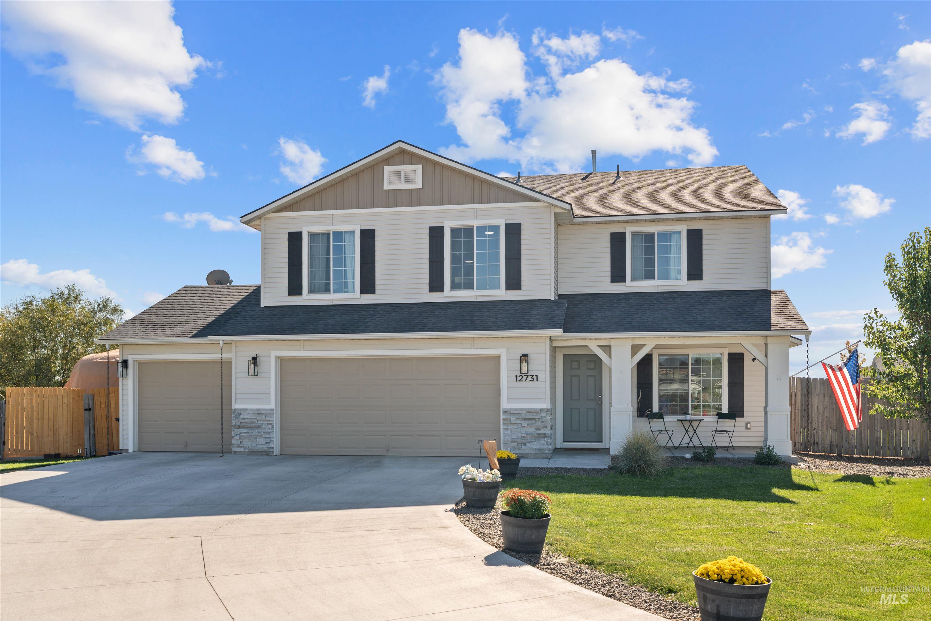 Traditional-style home featuring covered porch, roof with shingles, concrete driveway, a garage, and stone siding