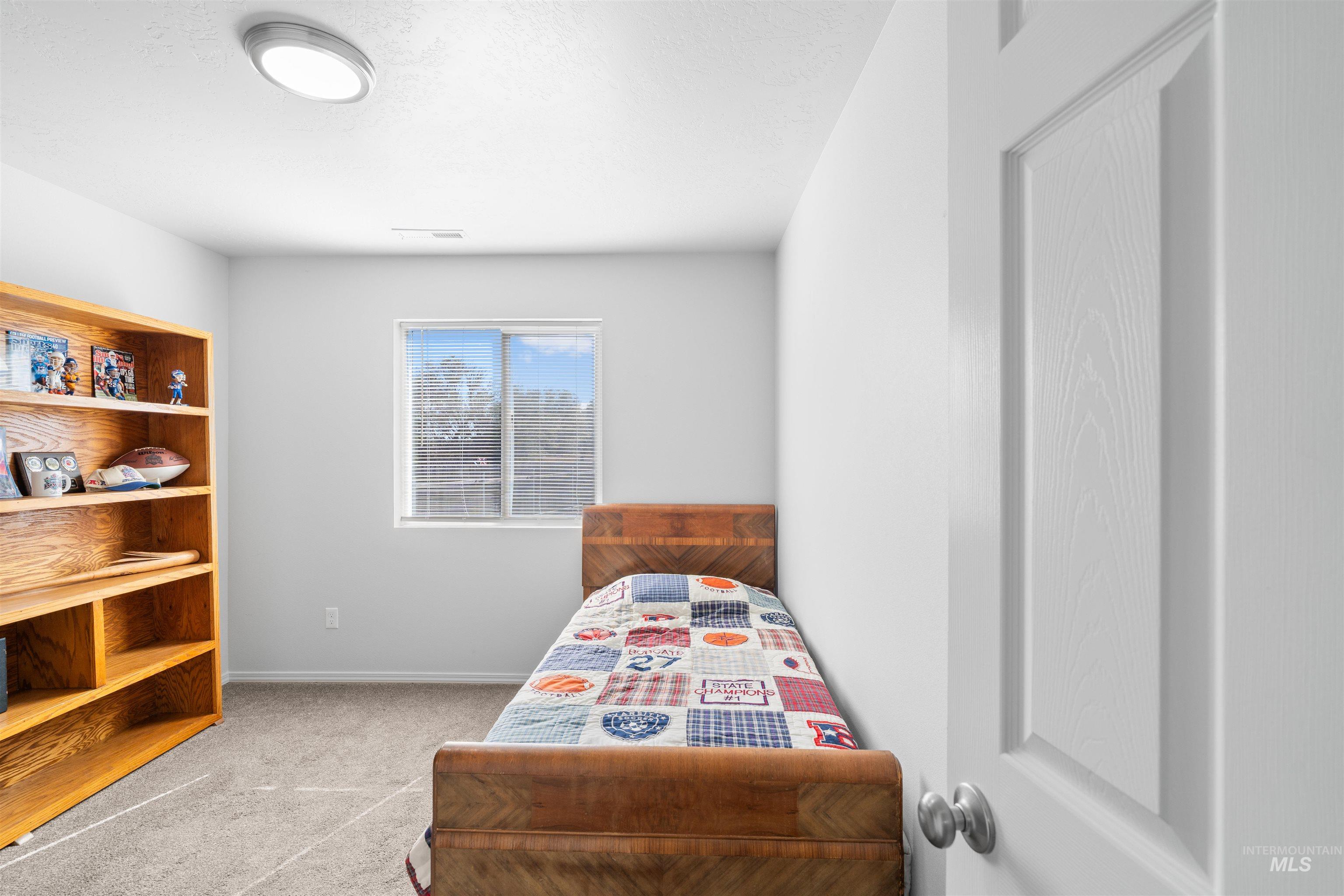 12731 Sondra Street Caldwell, ID 83607 - Photo 14 of 46 Bedroom with light carpet and baseboards