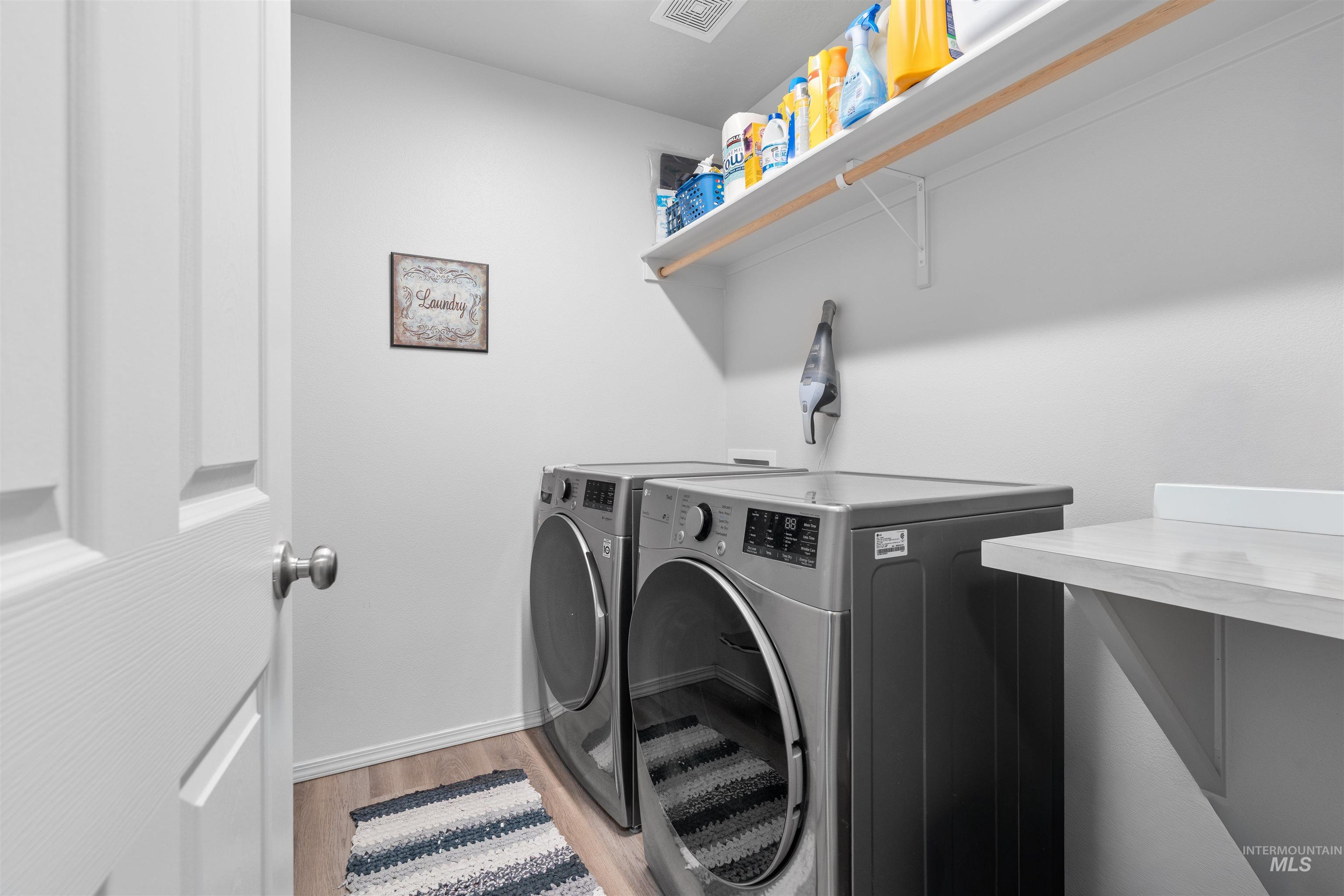 12731 Sondra Street Caldwell, ID 83607 - Photo 16 of 46 Laundry room with light wood-style floors and washing machine and clothes dryer