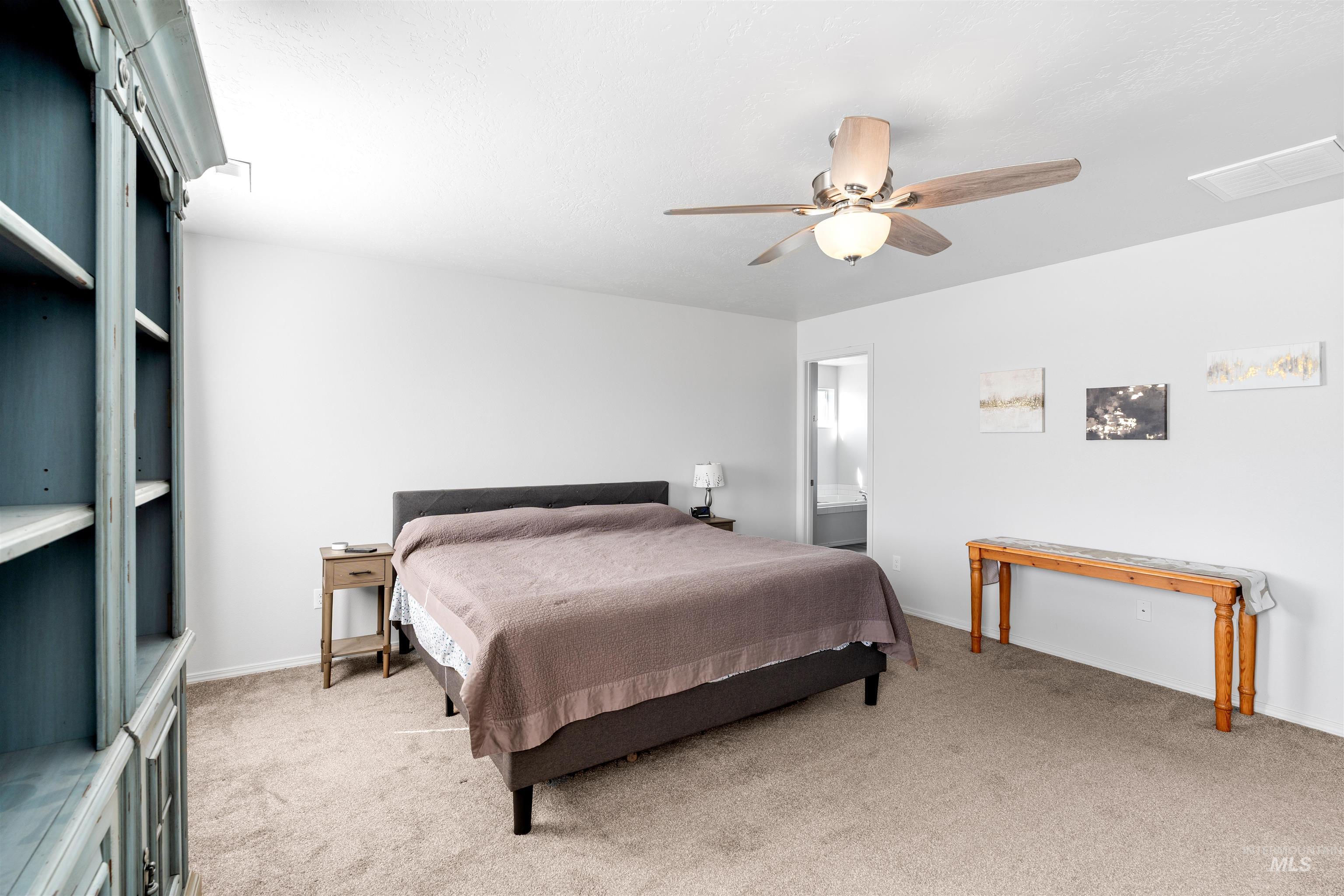 12731 Sondra Street Caldwell, ID 83607 - Photo 20 of 46 Bedroom with light carpet, a ceiling fan, and ensuite bathroom