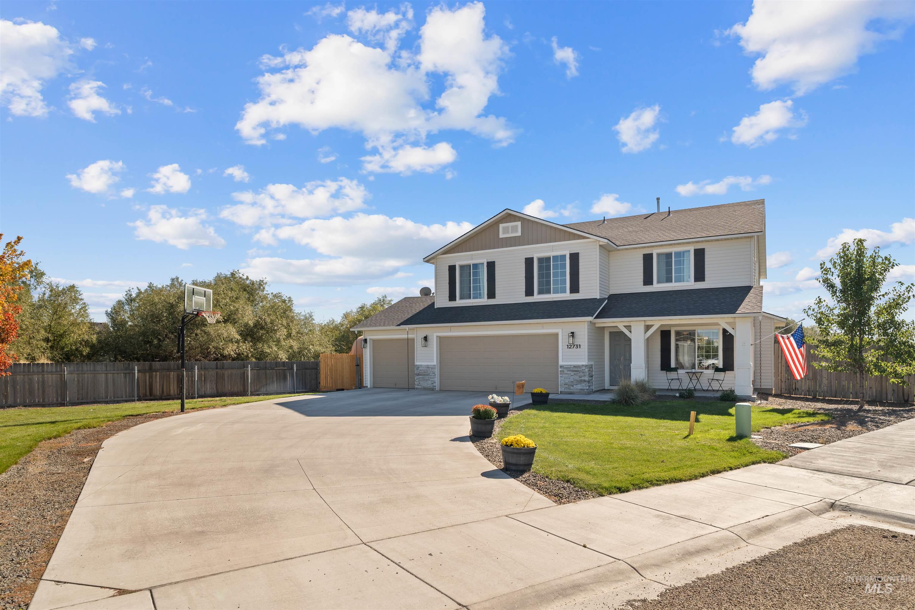 12731 Sondra Street Caldwell, ID 83607 - Photo 2 of 46 View of front facade featuring concrete driveway, an attached garage, covered porch, and a shingled roof