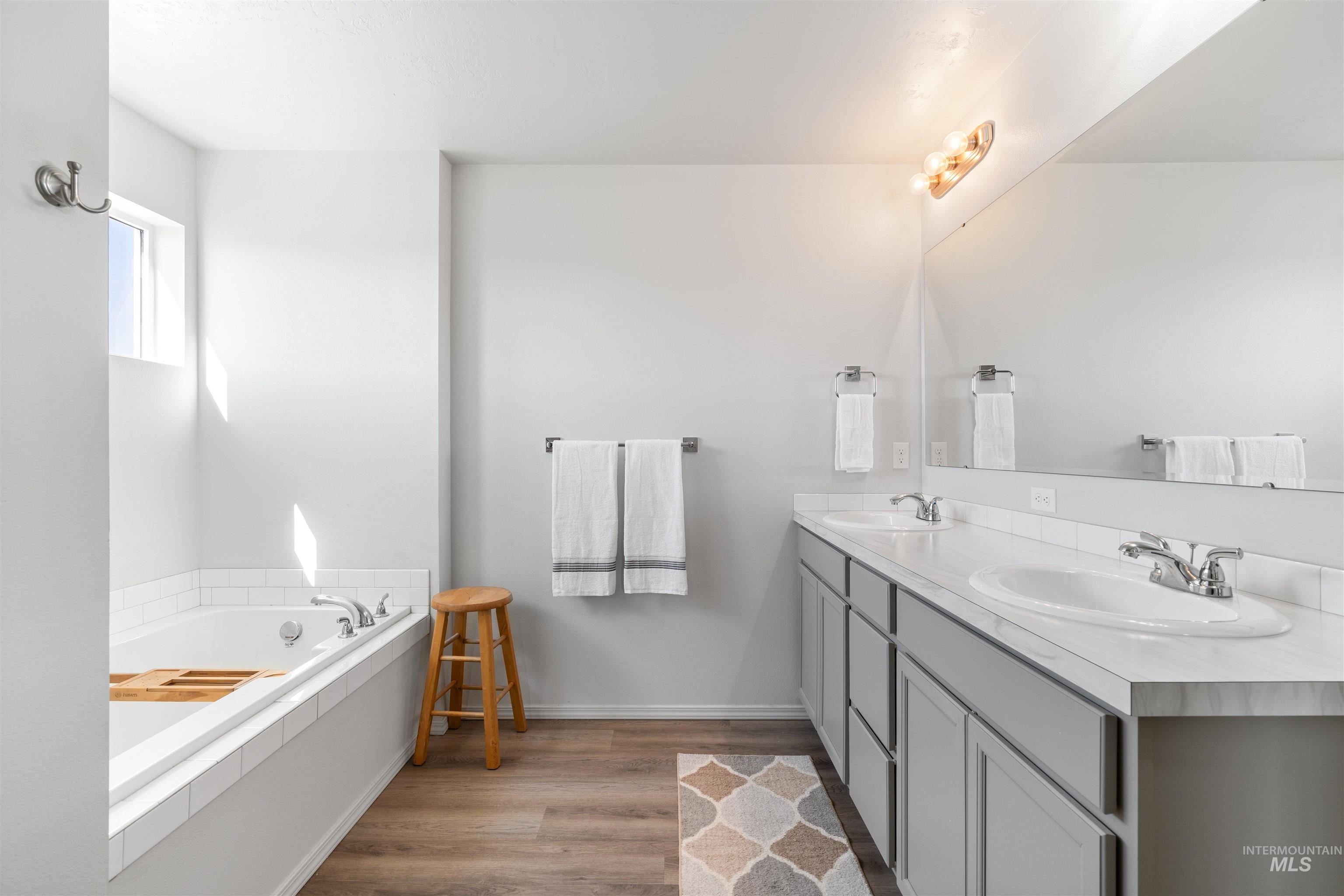 12731 Sondra Street Caldwell, ID 83607 - Photo 23 of 46 Full bath featuring double vanity, a bath, and dark wood-type flooring