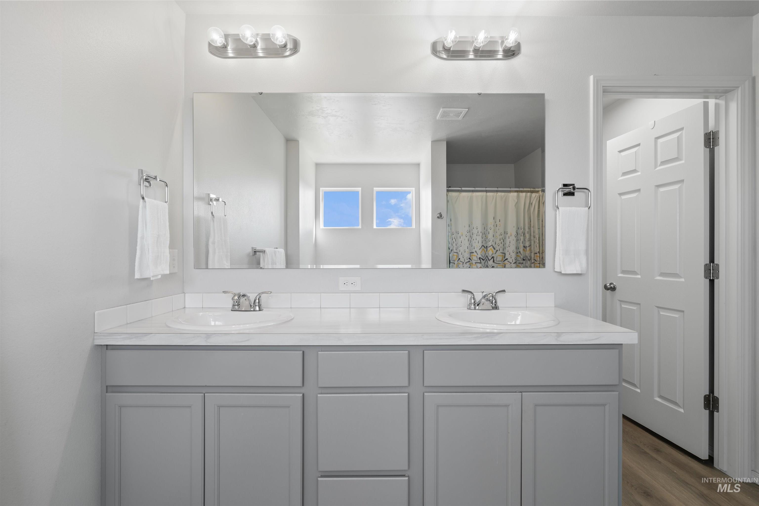 12731 Sondra Street Caldwell, ID 83607 - Photo 24 of 46 Full bathroom featuring double vanity, wood finished floors, and a shower with curtain