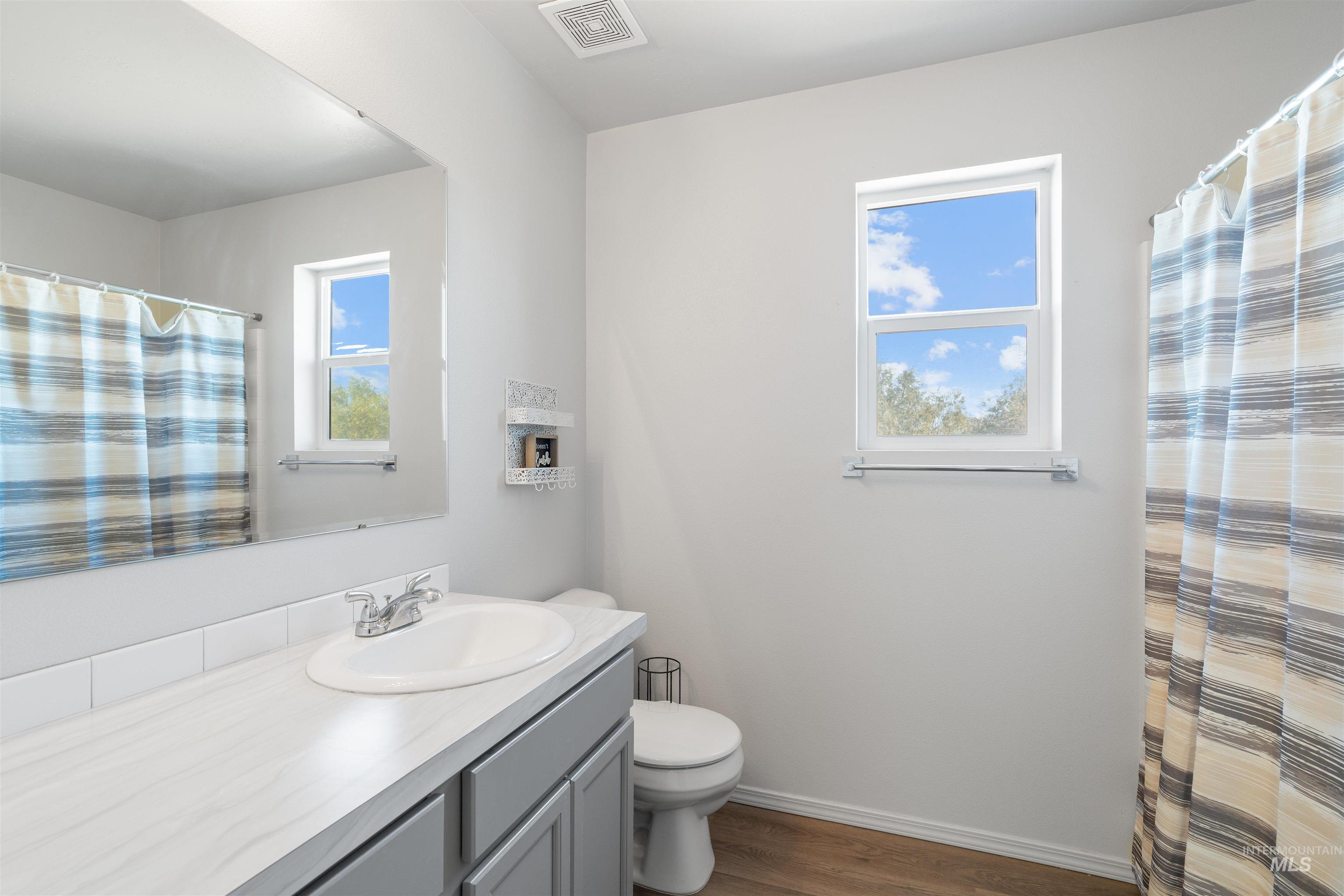 12731 Sondra Street Caldwell, ID 83607 - Photo 29 of 46 Full bathroom featuring dark wood-style floors, vanity, and curtained shower