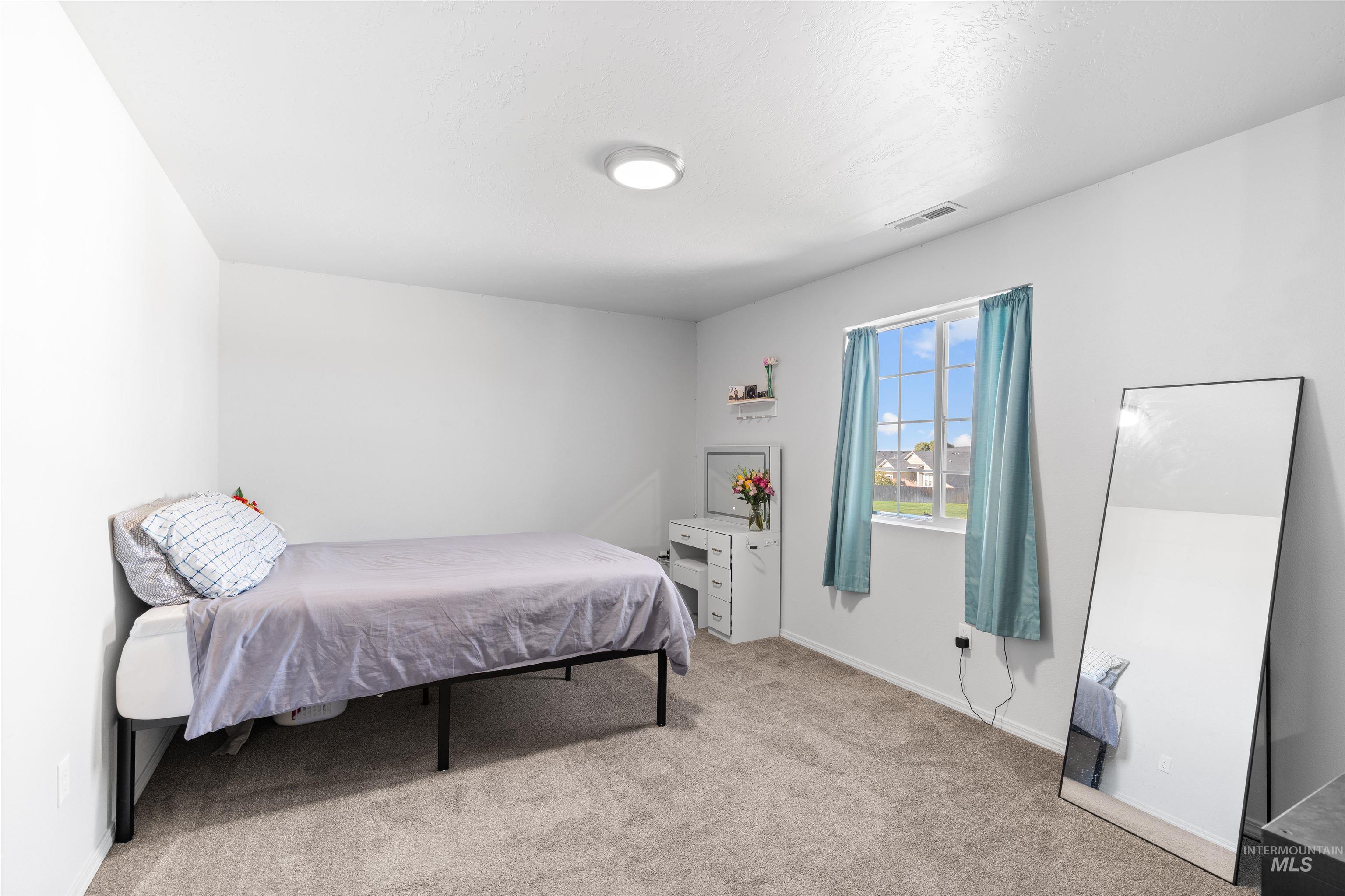 12731 Sondra Street Caldwell, ID 83607 - Photo 35 of 46 Bedroom with light carpet and baseboards