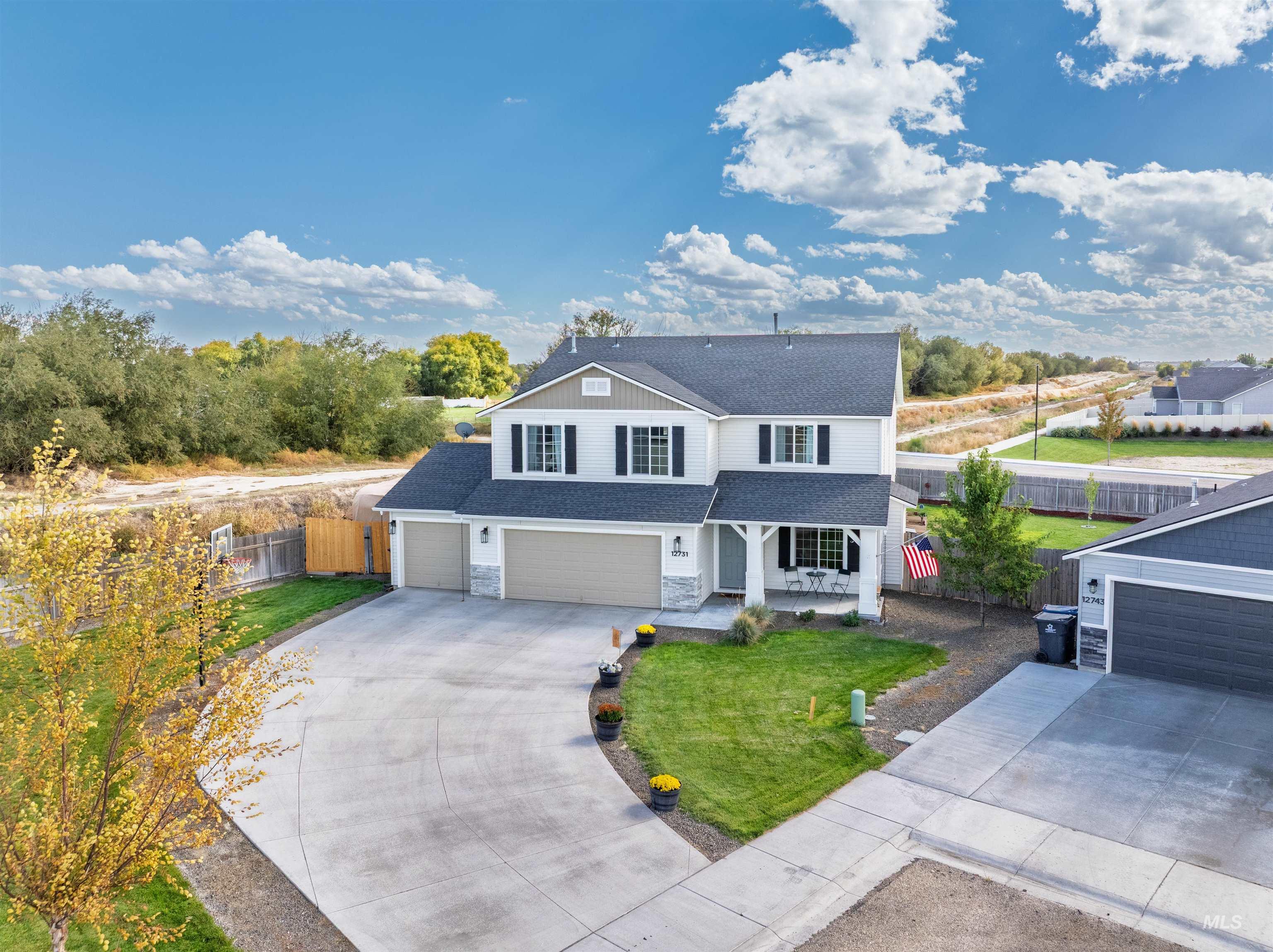 12731 Sondra Street Caldwell, ID 83607 - Photo 38 of 46 Traditional home with a shingled roof, covered porch, concrete driveway, a garage, and stone siding