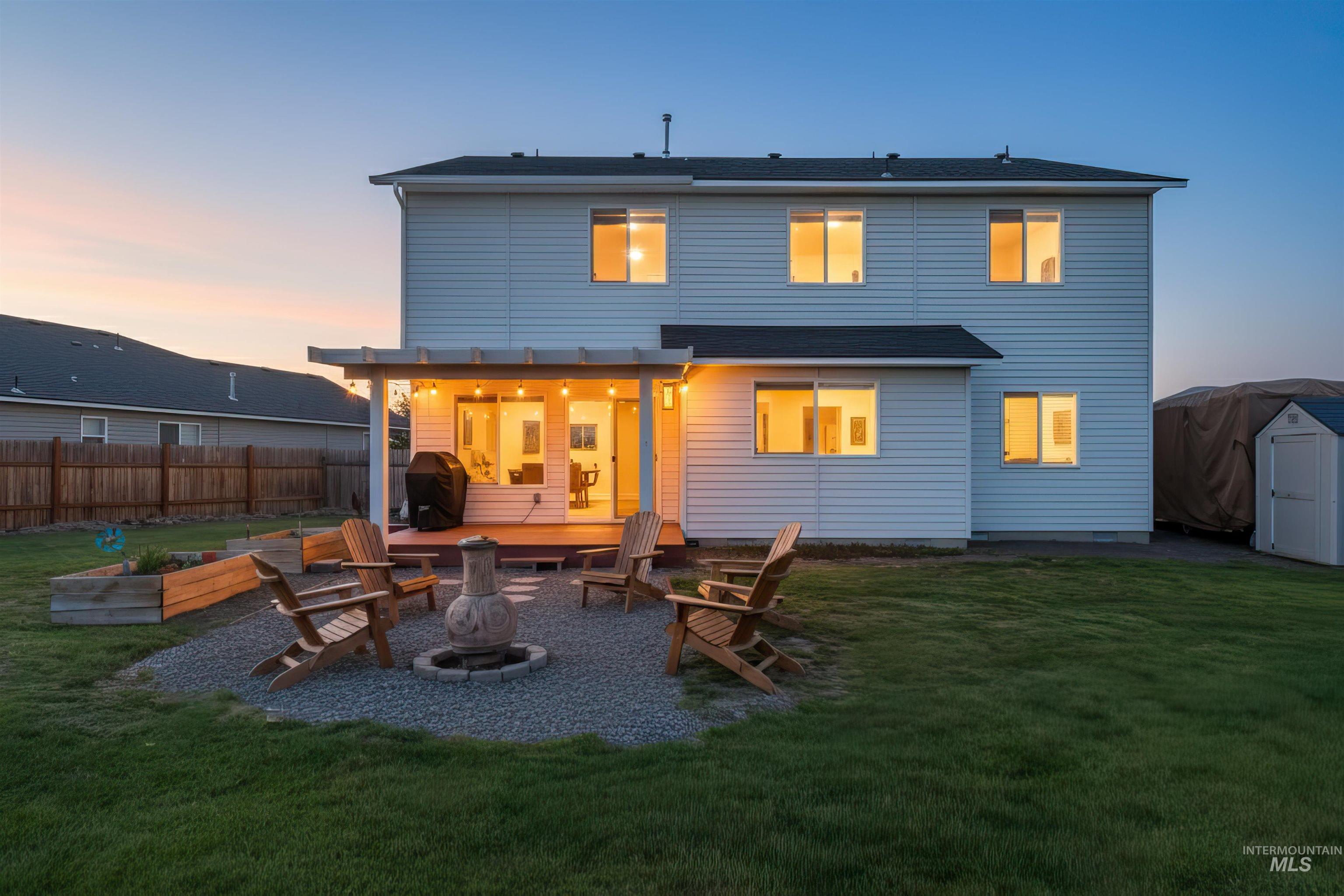 12731 Sondra Street Caldwell, ID 83607 - Photo 44 of 46 Rear view of house with a fire pit, a patio area, and a shed. Virtual twilight.