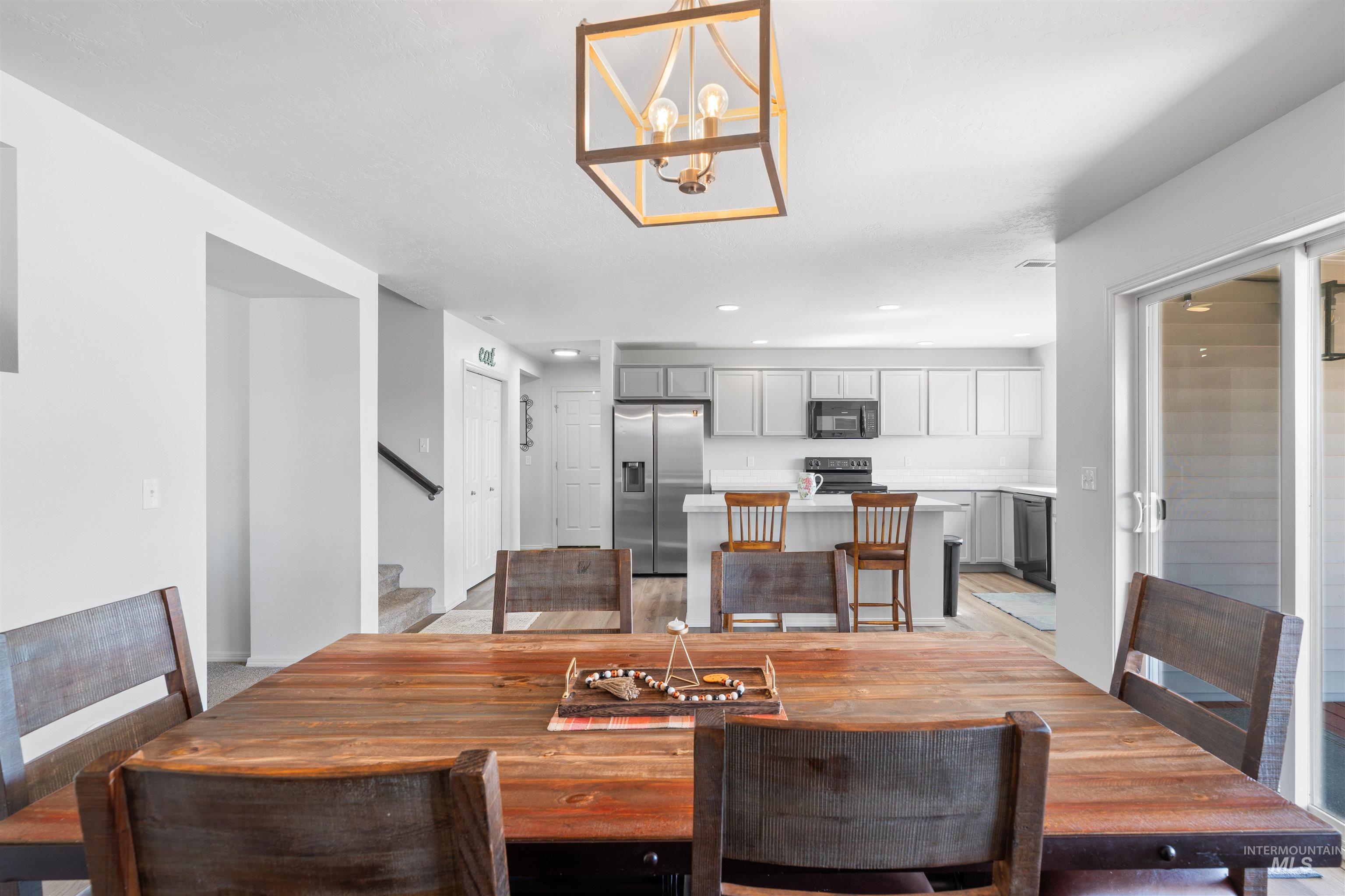 12731 Sondra Street Caldwell, ID 83607 - Photo 10 of 46 Dining area featuring a chandelier, stairway, light wood finished floors, and recessed lighting