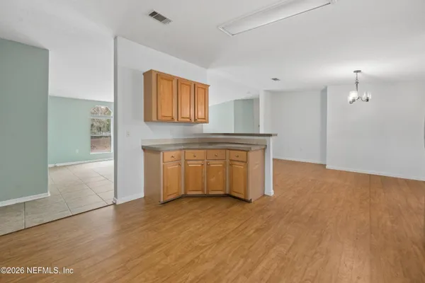 a view of a kitchen with wooden floor and electronic appliances
