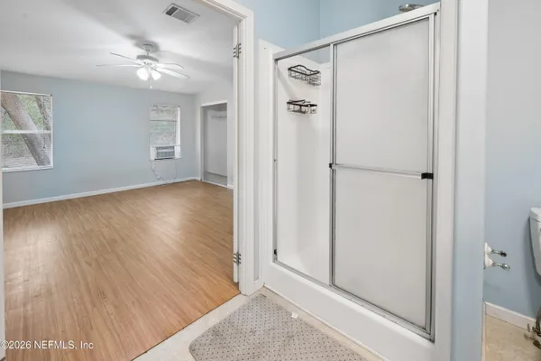 a view of a hallway with wooden floor and closet