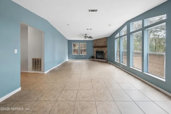 a view of an empty room with a fireplace and a window