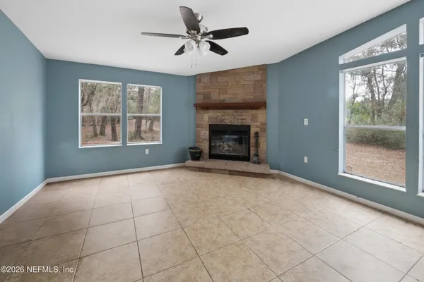 a view of an empty room with a fireplace and a window